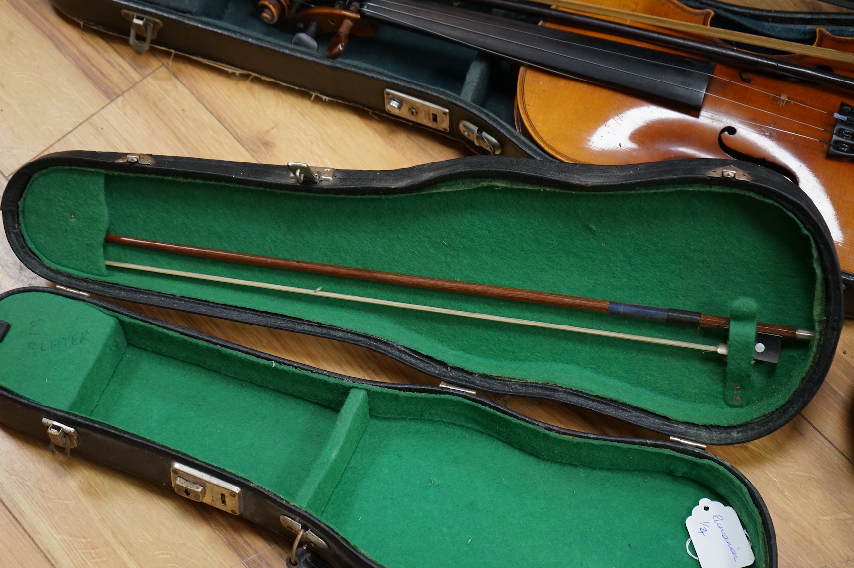 Five cased 20th century violins, including; a German violin, two Czech violins, a three-quarter size violin with a label for Bienfait, and a Romanian quarter size violin, all in cases or the remains of cases.